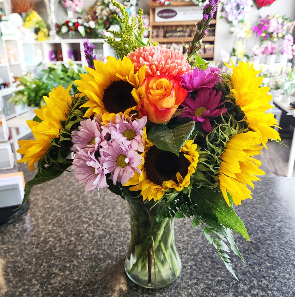 Sunflowers and roses flower arrangement designed for a Paris flower delivery.